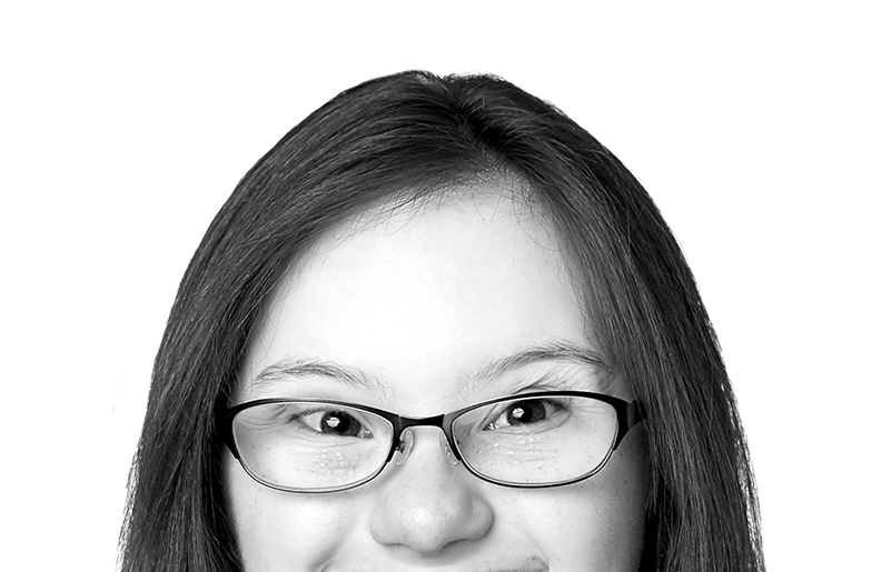A person with long hair and glasses is smiling at the camera. We can see their eyes and nose, but the photo is cropped above their mouth.