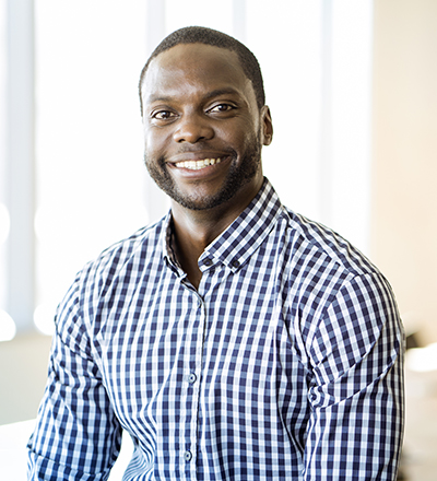 A man is sitting and smiling.